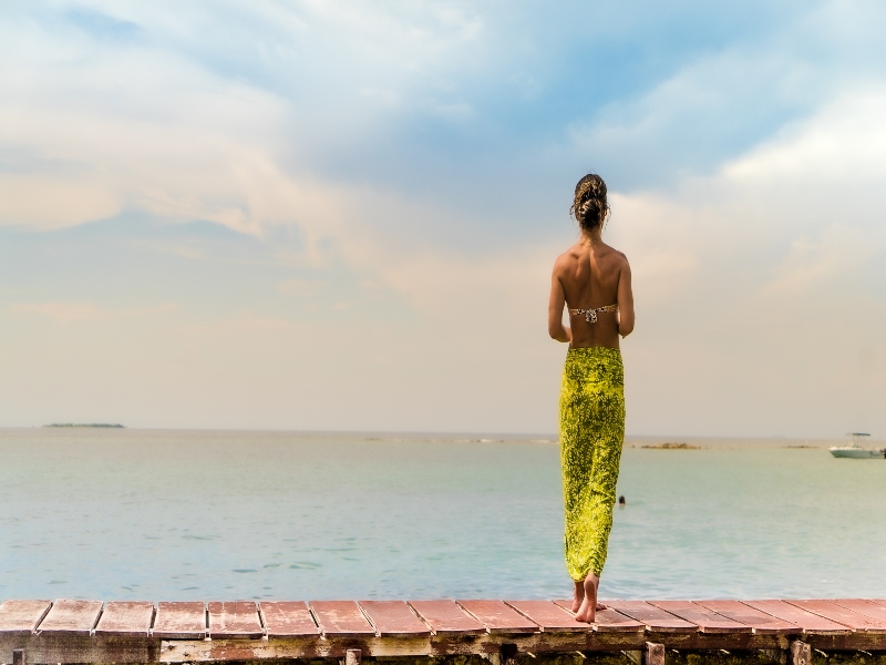 Mujer meditando en las Islas de Rosario como escenario, un destino ideal para lograr un fabuloso bienestar físico.